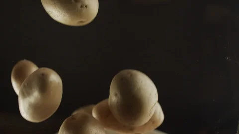 Close-up many fresh potatoes fall on clear glass. Slow motion video Stock Footage 116307078