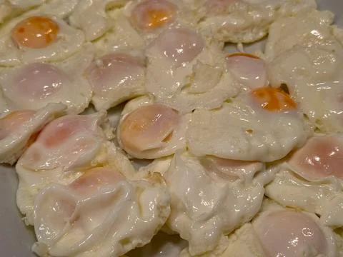 A close up of many fried eggs ready to eat for breakfast or brunch meal Stock Photos