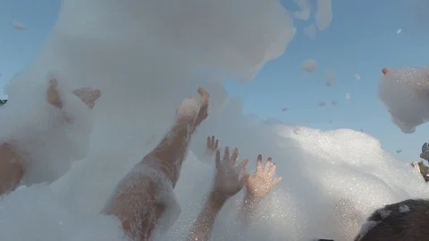 Close-up - many hands of people dancing in the foam. Foam party at the water Stock Footage