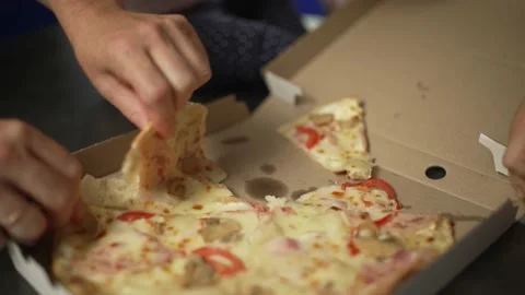 Close-up of many hands taking slices of pizza from the box. Stock Footage 229702312