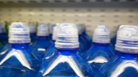 Close-up of many nice plastic bottles of potable water on a store shelf Vidéo 277476168