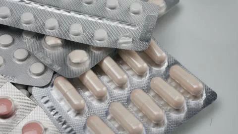 Close up, many packed pills rotating on white background Stock Photos