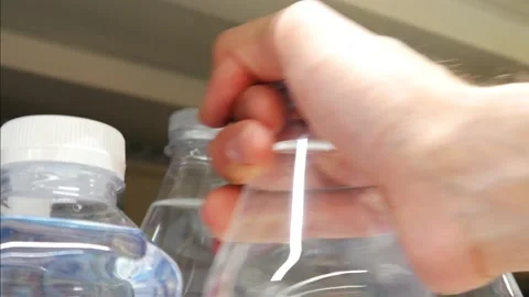 Close-up of many plastic bottles with potable water and a man's hand takes one Vidéo 218788140
