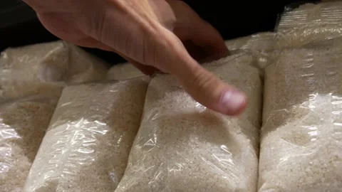 Close-up of many rice packagings and a male hand takes one Stock Footage 197854091