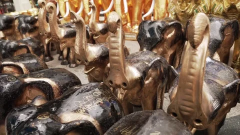 Close-up of many rows of golden elephant figures with a raised up trunk standing 動画素材 289430097