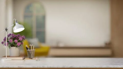Close up of a marble desk with white lamp, purple flowers in pot over a boo.. Stock Illustration