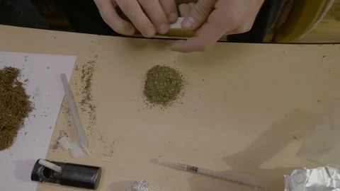Close up of a marijuana addicted man separating the weed quantity on the tabl Stock Footage 86879980