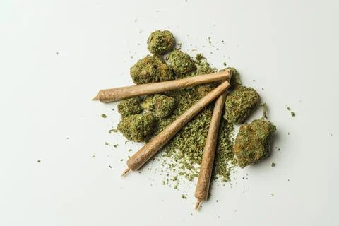 Close up of marijuana joint and buds on white background. Фото