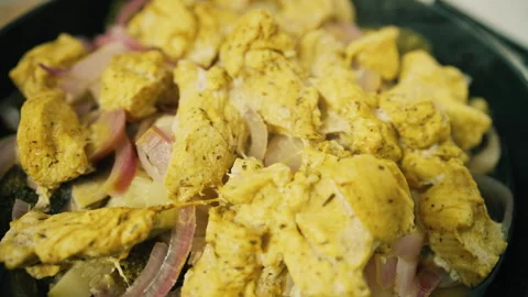 Close up of marinated chicken and onion sizzling in a pan with spices during Stock Footage 345080642
