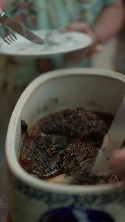 Close-up of marinated meat and herbs inside ceramic mug with blurred plate in Stock Footage 345272237