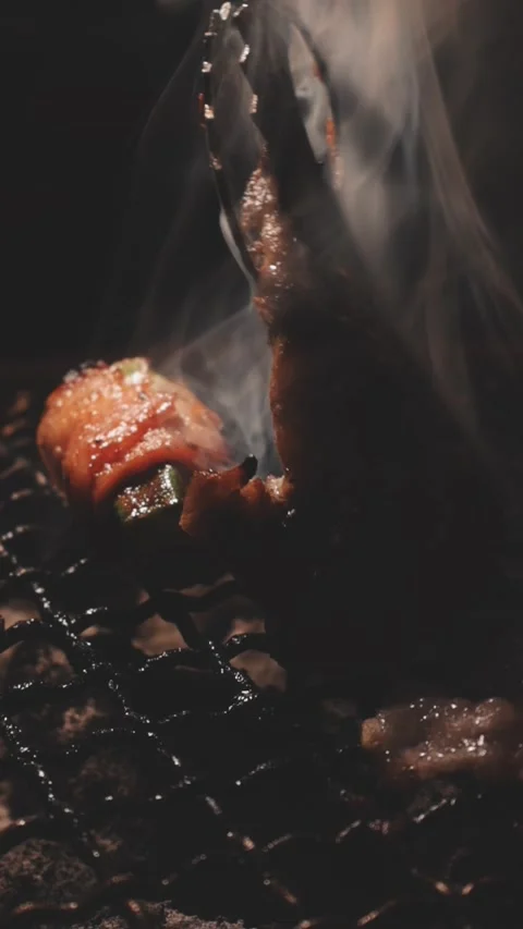 Close-up of marinated pork sizzling on a wire mesh gridiron over hot charcoal Stock Footage 344921891
