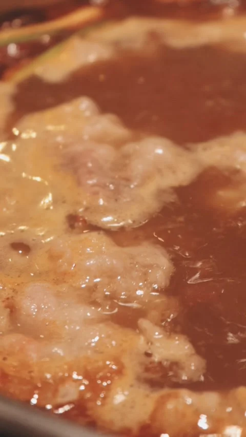 Close-up of marinated pork sizzling on a wire mesh gridiron over hot charcoal Vidéo 344921925