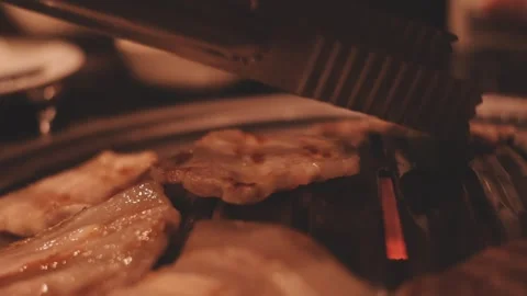 Close-up of marinated pork sizzling on a wire mesh gridiron over hot charcoal Stock Footage 344922064