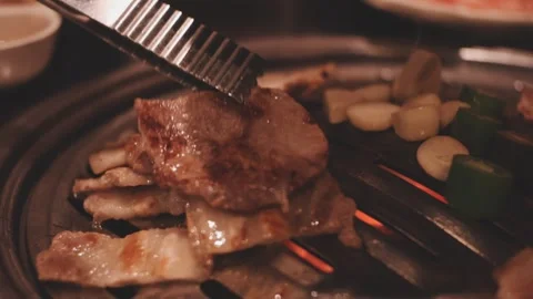 Close-up of marinated pork sizzling on a wire mesh gridiron over hot charcoal Stock Footage 344922100