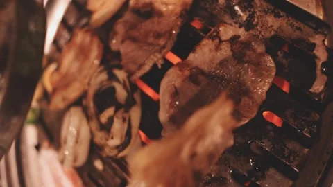 Close-up of marinated pork sizzling on a wire mesh gridiron over hot charcoal Stock Footage 344922163