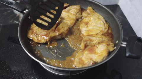 Close-up of marinated pork steaks cooking in savory sauce in a frying pan o.. Video stock 340147919