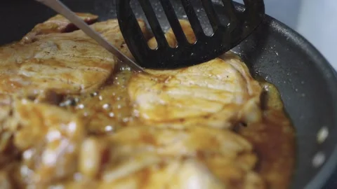 Close-up of marinated pork steaks cooking in savory sauce in a frying pan o.. Stock Footage 340635870