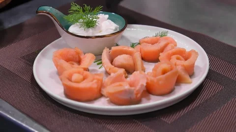 Close-up of marinated salmon pieces on white plate with sauce Video stock 267668367