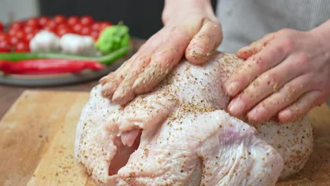 Close-up of marinating a whole raw chicken with black pepper, salt, coriander. Stock Footage 145104995