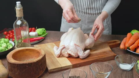 Close-up of marinating a whole raw chicken with black pepper, salt, coriander. Stock Footage 145105364