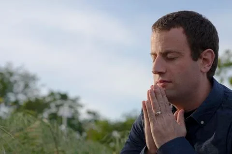 Close up of married man praying outside. Stock Photos