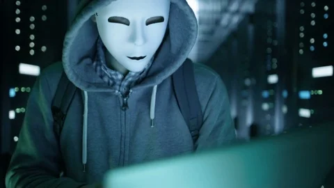Close-up of a Masked Hacker in Data Server Hacking Into System. Stock Footage 73936381