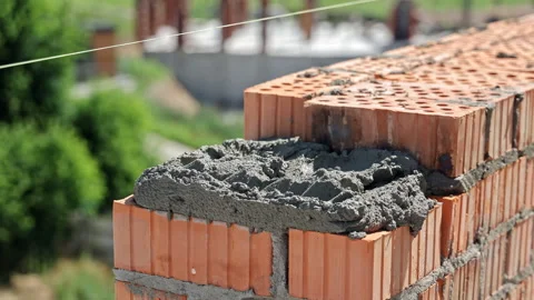 Close-Up of Mason Laying Clay Bricks with Cement Mortar, Wearing Gloves and Stock Footage 312738886