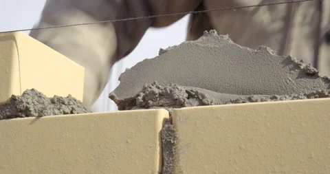 Close-up of masonry, builder puts mortar on already laid bricks, smoothes it Stock Footage 130367991