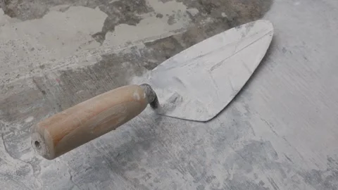 Close Up of Masonry Trowel Resting on Concrete Construction Surface Stock Footage 341841397