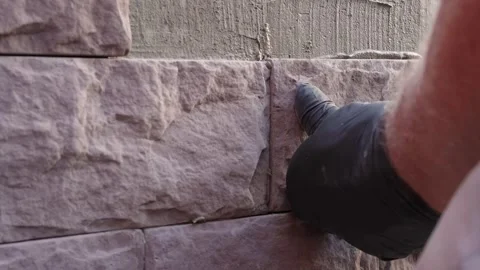 Close-up of masonry work as a construction worker presses decorative stone Video stock 318471334