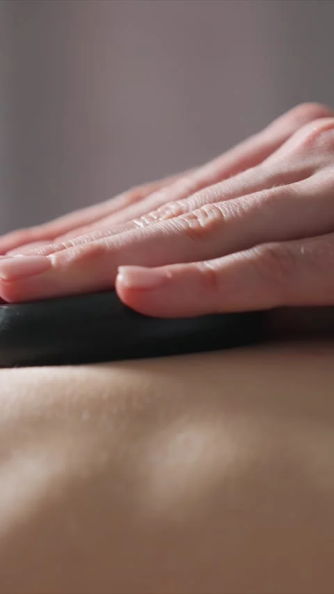 Close up Massage with Smooth Black Stones on Back Detail with bodywork Stock Footage 346795688