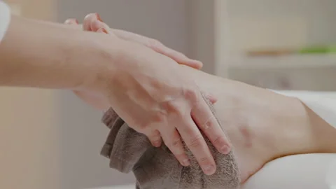 Close up masseur hands wiping client feet with hot towel after spa massage. Stock Footage 197658468
