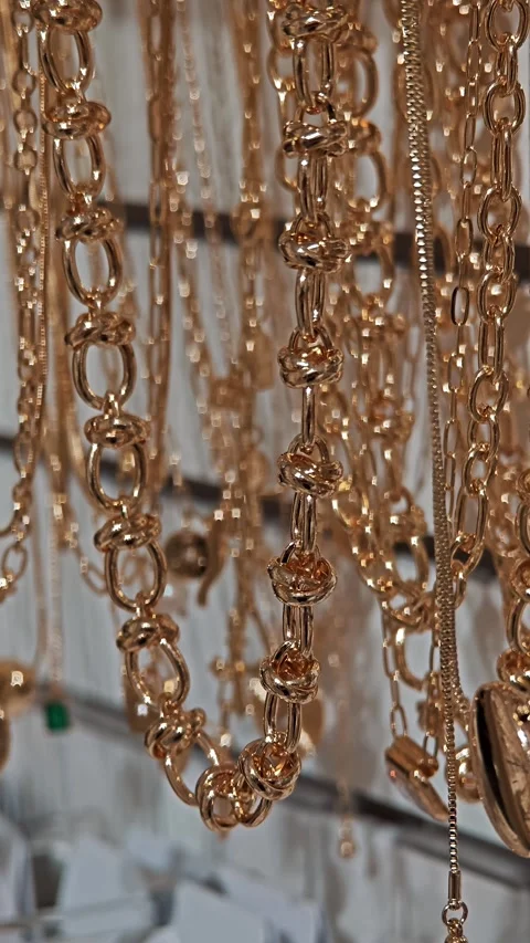 Close up of massive gold chains shining under lamp light, showcasing luxury Stock Footage 330789911