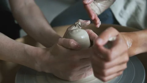 Close-up of master and apprentice hands on potter's wheel Video stock 238699559
