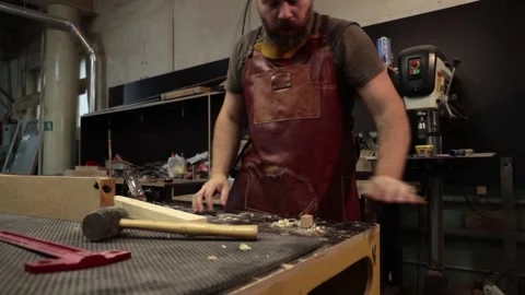 Close up master carpenter in an apron planes tree with a plane in workshop Stock Footage 157105759