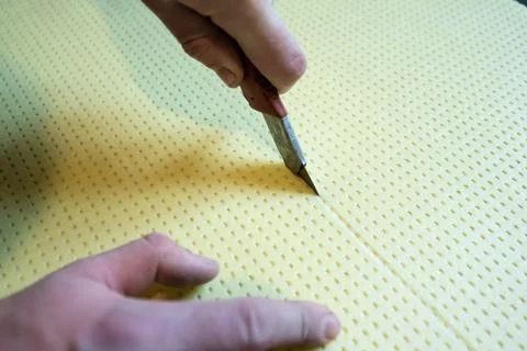 Close-up of the master cuts the size of expanded polystyrene on the floor, th Fotos de archivo