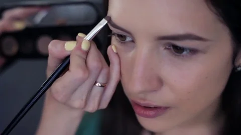 Close-up. The master does makeup to the girl in the beauty salon Stock Footage 83844059