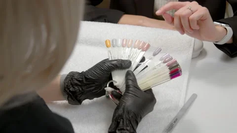 A close-up of a master doing a manicure to a young girl in a beauty salon. The Stock Footage 171760858