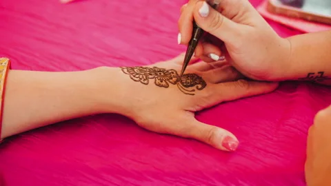 Close-up of master draws mehendi tattoo on the hand of unrecognizable person on Stock Footage 239712872