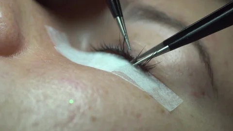Close-up of master lash maker remove old eyelashes of young woman Video stock 74853771