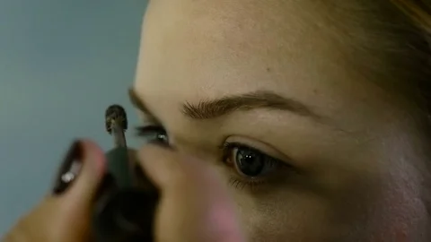 Close up. The master in a make-up prepares model for display. The girl puts with 스톡 동영상 82081340