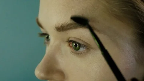 Close up. The master in a make-up prepares model for display. The girl puts with 스톡 동영상 82081673