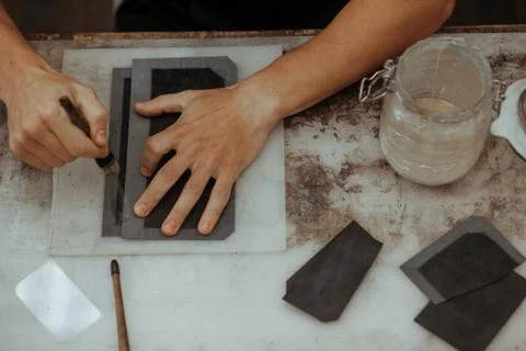 Close up of master making leather wallet with brush and glue. Handmade master at Stock Photos