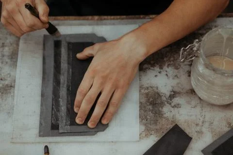 Close up of master making leather wallet with brush and glue. Handmade master at Stockfoto's