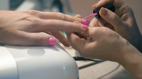 Close-up, Master of Manicure: Applying Pink Lacquer on Nails on Woman's Hand Stock Footage 92173955