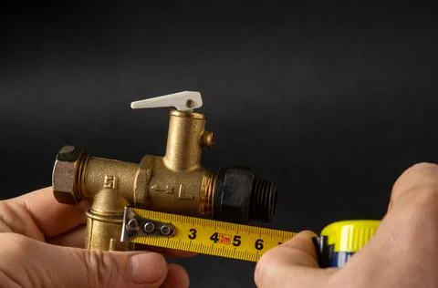 Close up of a master measuring the size of a plumbing valve Stock Photos