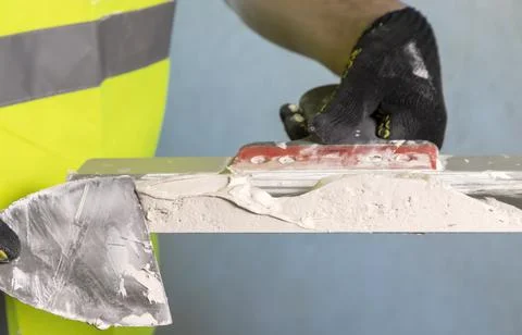 Close up of the master mixes the plaster mixture on a spatula for application to Stock Photos