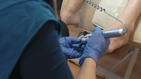 Close-up, Master of Pedicure Scrub Nail on Woman's Leg Before Applying Lacquer Stock Footage 92184696