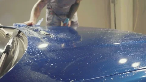 Close up of master polishing deep blue car in workshop, slow motion Stock Footage 82330983