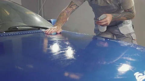 Close up of master polishing deep blue car in workshop, slow motion Stock Footage 82331272